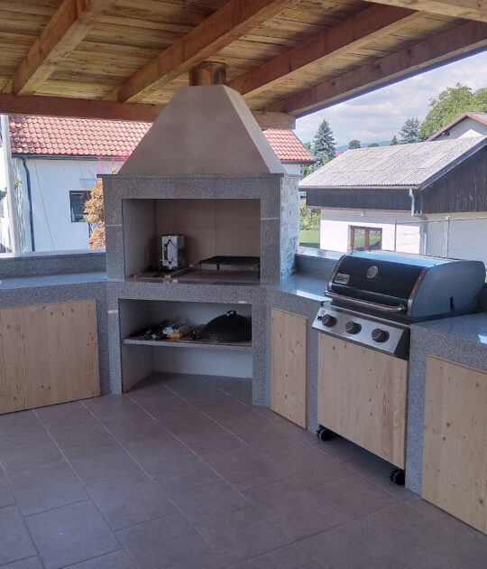 Vrtni kamin s kamnitimi pulti in omaricami ter prostorom za žar